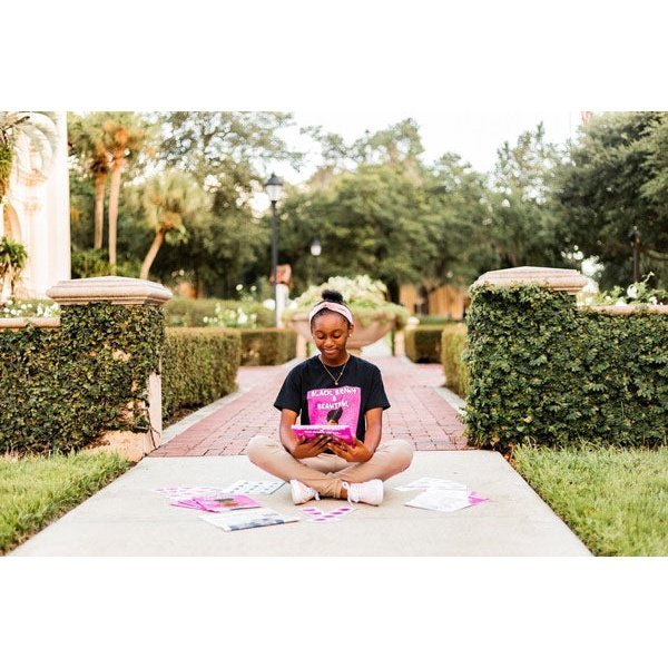 Author Sumer Strawbree's Photo, Sitting on a Park with her Books and Stickers